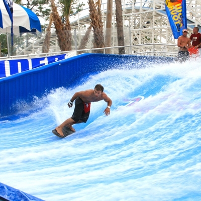 El practicar surf artificial del paseo del agua de Flowrider de las atracciones del agua para dos personas que practica surf